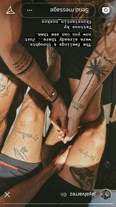 two men with tattoos on their legs holding hands and touching each other's fingers