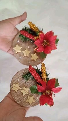 two handmade christmas decorations are being held by someone's fingers on a white surface