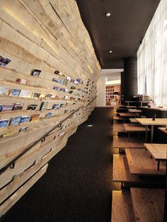 the inside of a restaurant with wooden tables and benches lined up against the wall that has pictures on it