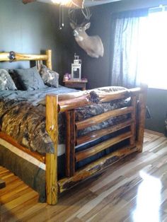 a bed made out of wooden pallets with a deer head on the wall above it