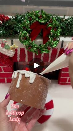 a person is decorating a gingerbread house with icing and candy canes