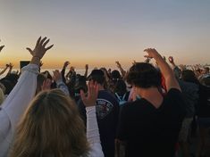 a group of people raising their hands in the air