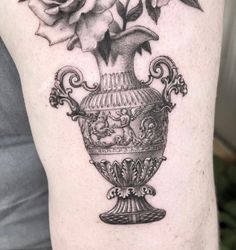 a black and white photo of a vase with flowers on it's side arm