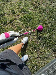 a person holding onto a pink object in the grass