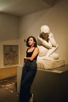 a woman standing next to a statue in a museum