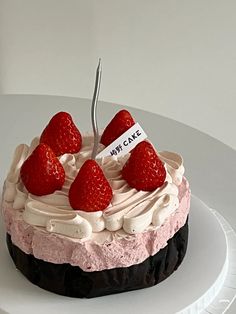 a white plate topped with a cake covered in frosting and strawberries