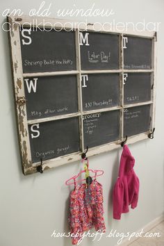 an old window is hung on the wall next to a coat rack with clothes hanging from it