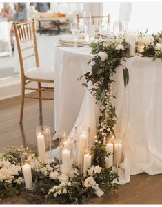 a table is set with candles and flowers on the floor for an elegant wedding reception