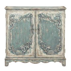 an old blue cabinet with ornate carvings on the front and sides, against a white background