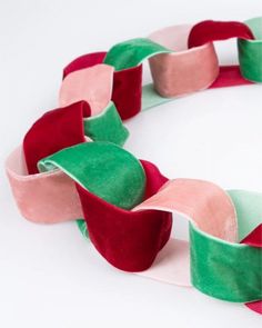 a red, green and pink ribbon on a white surface