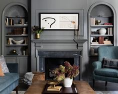 a living room filled with furniture and a fire place in front of a book shelf