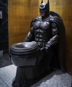 a batman statue sitting on top of a toilet