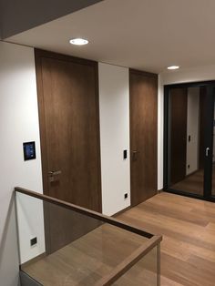 an empty room with wooden floors and glass balconies on either side of the door