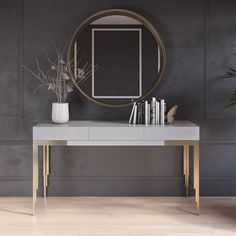 a white table with a mirror and books on it in front of a gray wall