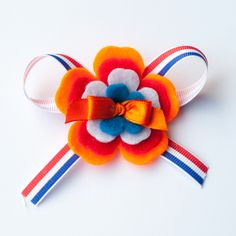 a red, white and blue flower with a bow on it