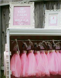 pink tutu skirts are hanging on a shelf