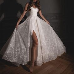 a woman in a white dress is standing on a wooden floor with her legs spread out