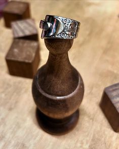 a wooden vase with a metal ring on it's top sitting on a table