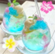 two glasses filled with ice cream and sprinkles on top of a wooden table