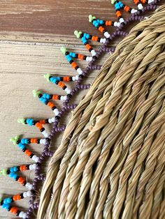 a wicker basket filled with beads on top of a wooden table