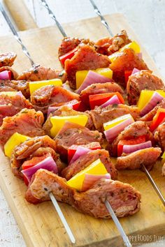 several skewered meats and vegetables on a cutting board with toothpicks