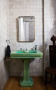 a bathroom with a green sink and mirror