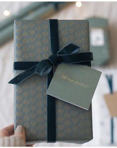 a person is holding a gift wrapped in blue paper