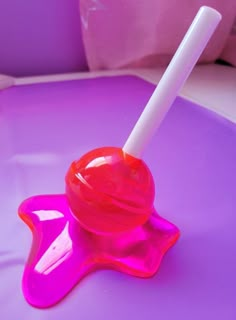 a pink liquid bottle with a white stick sticking out of it on a purple surface