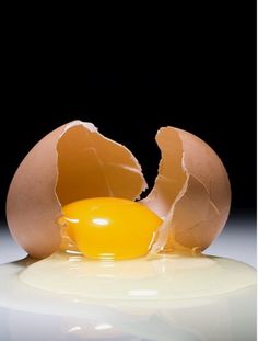 an egg is broken in half on a white surface