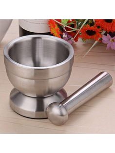 a metal bowl and spoon on a table