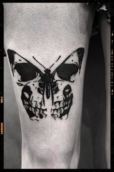 a black and white photo of a butterfly with skulls on it's side leg