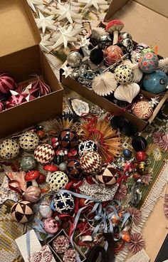 two boxes filled with assorted ornaments on top of a table