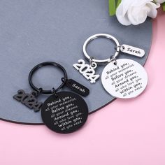 personalized keychains with names and dates on them sitting on a pink background