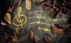 yellow chalk drawing on cement with music notes and leaves