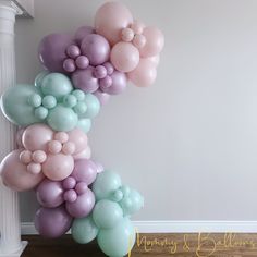 the balloon arch is decorated with pastel colors