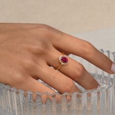 "Genuine Ruby Vintage Engagement Ring/Ruby Ring With Diamond Halo/14k Solid Gold/Oval Shape Ruby Ring/Wedding Anniversary/July Birthstone ★ ★ ★ ★  CUSTOM/DUTY-FREE SHIPPING WORLDWIDE, BUYERS DON'T HAVE TO PAY ANY CUSTOM FEES WHILE IMPORTING ★ ★ ★ ★  Details Made to order Material: 14k/18k gold Color Options: Yellow Gold, White Gold, Rose Gold ★ Center Stone Ruby, Oval Size: 5X7 mm Approx Weight (Ct): 0.96 ★ Accent Stones Diamond/Moissanite Round Size: 1.1 mm * 16 No.s , 1.5 mm * 4 Nos. Approx Weight (Ct): 0.15 ★ Band Width: 1.3 mm ★ Ring Height: 7 mm Procedure information ★ 100% Natural Diamond and Gemstones ★ Diamond: Round Brilliant cut, G-H Color, SI Clarity ☂ Shipped with Insured Shipping within 4-7 business days. ➦ 100% Free Returns. ➦ Our Jewelry comes with a Lifetime Warranty. (Ston Oval Ruby Ring With Diamond Halo, Oval Ruby Birthstone Ring With Halo Setting, Oval Ruby Ring For Proposal, Oval Ruby Promise Ring, Oval Ruby Birthstone Ring With Prong Setting, Oval Red Diamond Proposal Ring, Oval Ruby Ring With Halo In Fine Jewelry Style, Oval Ruby Wedding Ring In Fine Jewelry Style, Oval Ruby Ring With Prong Setting For Proposal