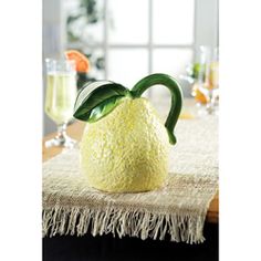 a white vase sitting on top of a table next to a glass filled with wine