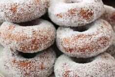 powdered sugar covered donuts piled on top of each other