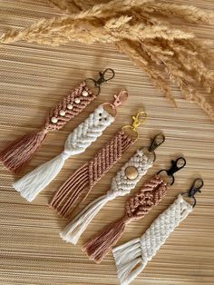 four tassels are sitting on a table next to some brown and white yarn