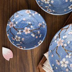 three blue dishes with pink flowers on them