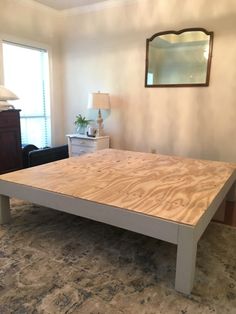 a wooden table sitting on top of a carpeted floor in a living room next to a window