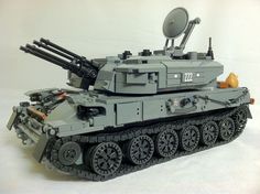 a toy tank is sitting on a white surface with an antenna attached to it's top