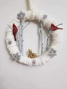 a white wreath with birds and snowflakes on it, hanging from the wall