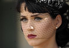 a close up of a woman wearing a veil over her head with red lipstick on it