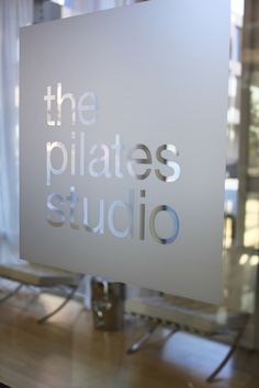 there is a sign that says the pilates studio in front of a window