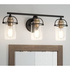 three light bathroom vanity fixture with clear glass jars on the top, and an antique wood frame