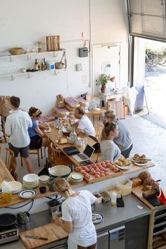 several people are in the kitchen preparing food