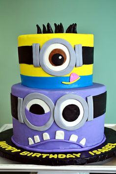 three tiered birthday cake decorated to look like a minion