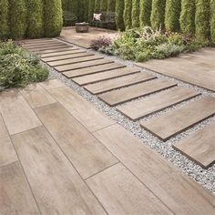 an outdoor garden with wooden steps leading to a bench and seating area in the background