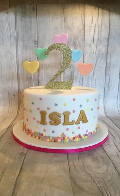 a birthday cake decorated with hearts and the number two is also made out of fondant